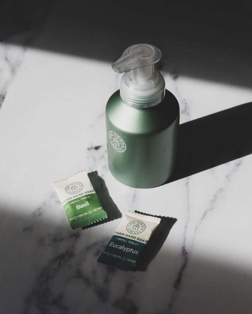 Biologisch afbreekbare sachets en groene pompflacon met natuurlijke shampoo, duurzame en plasticvrije verpakkingen