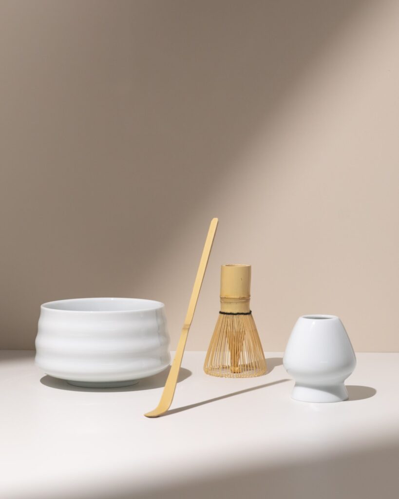 Matcha set met kom, klopper en roerstaal in een rustig compositie met sfeervolle lichtinval