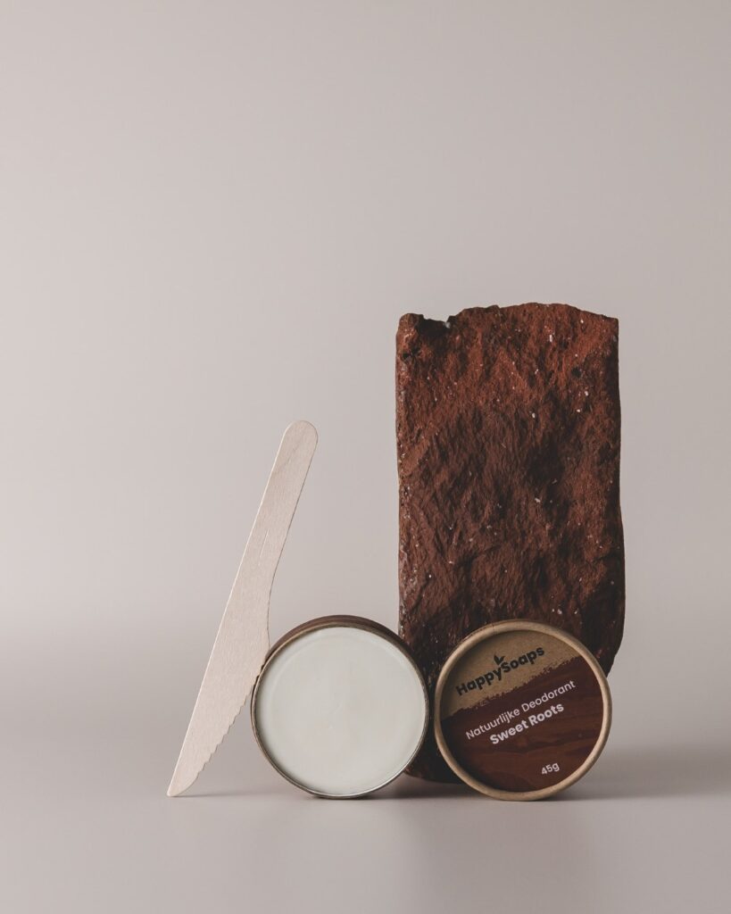 Natuurlijke deodorant in creme in duurzame verpakking langs een hergebruikte baksteen