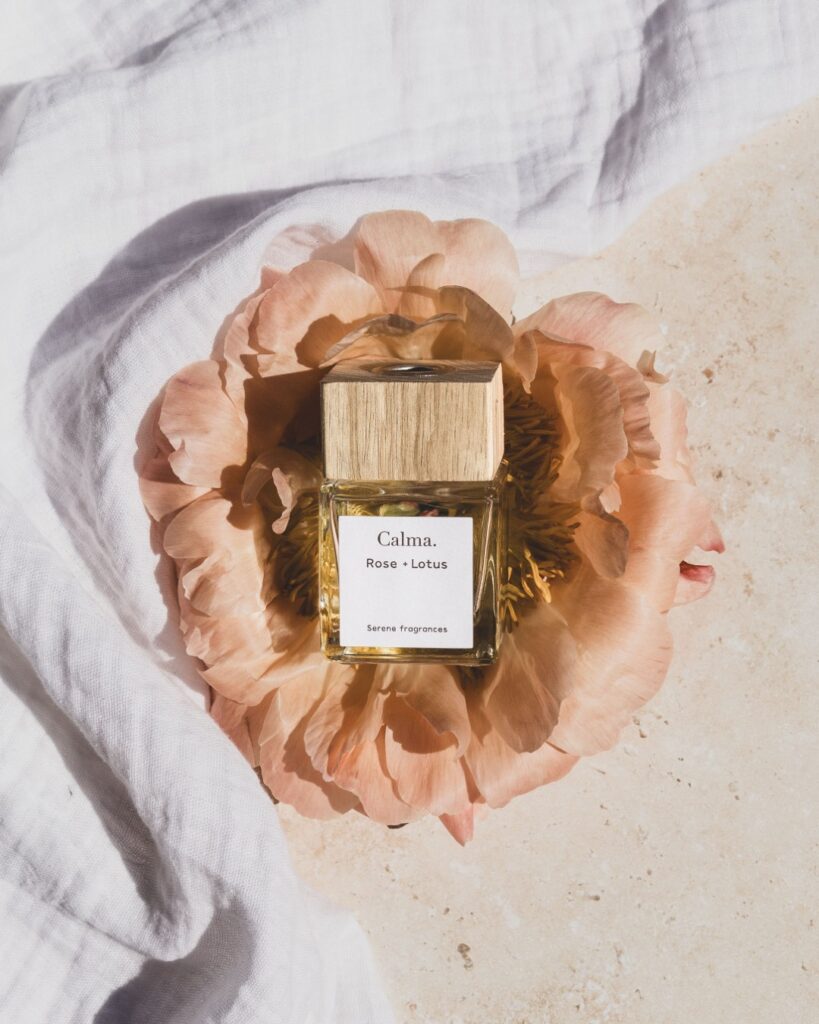 natuurlijke productfotografie van parfumflesje in pioenroos met vakantiegevoel